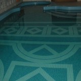 Чаша частного плавательного бассейна с интересным узором из мозаики