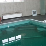 Переливной бассейн для плавания с римской мраморной лестницей