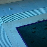 Бортик частного переливного бассейна, облицованный плиткой с противоскользящим покрытием