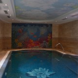Переливной бассейн в загородном доме с отделкой из смальты и большим мозаичным панно