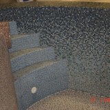Ступени лестницы в стационарном плавательном бассейне, облицованные мозаикой